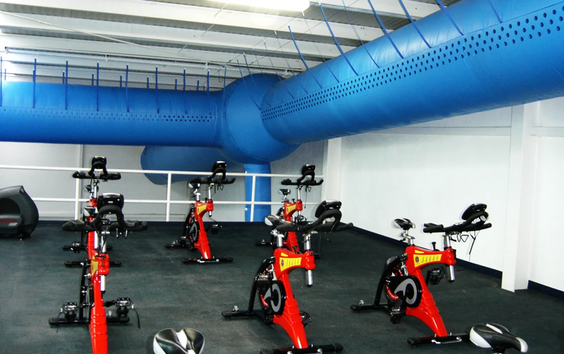 Sala de spinning com dutos têxteis